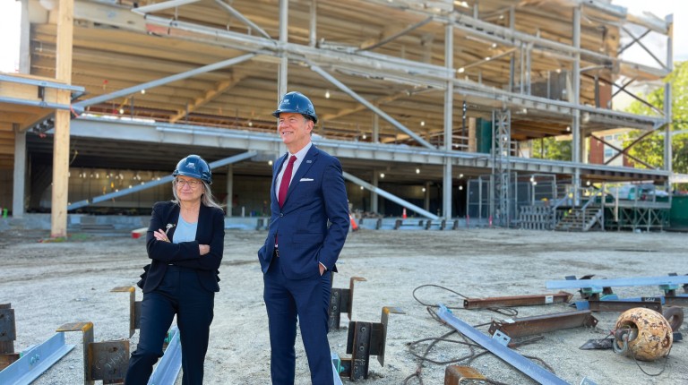 U N E President James Herbert and the College of Osteopathic Medicine dean stand in front of the construction of the Harold and Bibby Center for Health Sciences