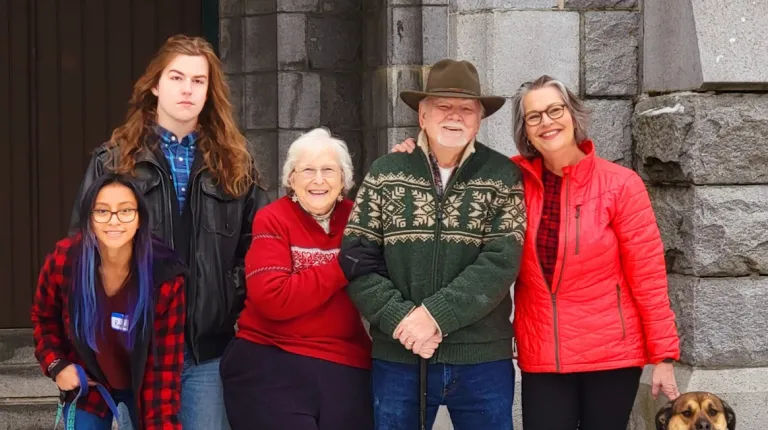 A family poses for a photo with a dog