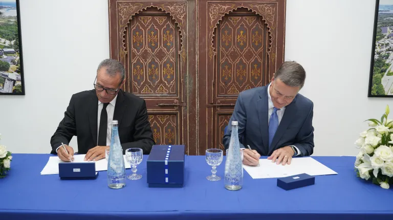 UNE President James Herbert and President Bouchta El Moumni of Abdelmalek Essaadi University sign an agreement at a formal table