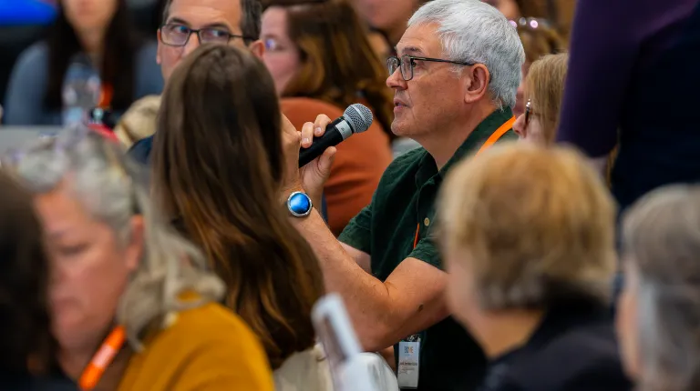A conference attendee asks a question into a microphone