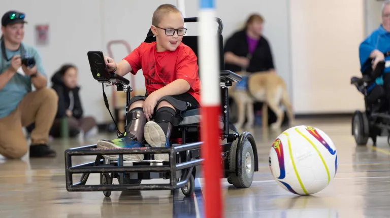 A young boy plays power soccer