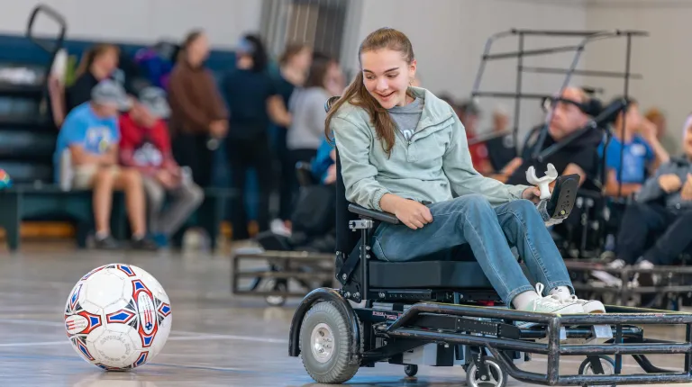 A wheelchair user plays power soccer