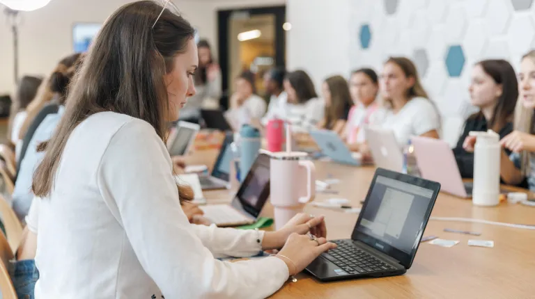 A UNE student works on her laptop
