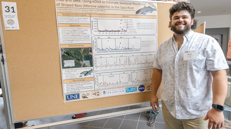 Kade Tyrell, a U N E marine science student, presents research on stripped bass.