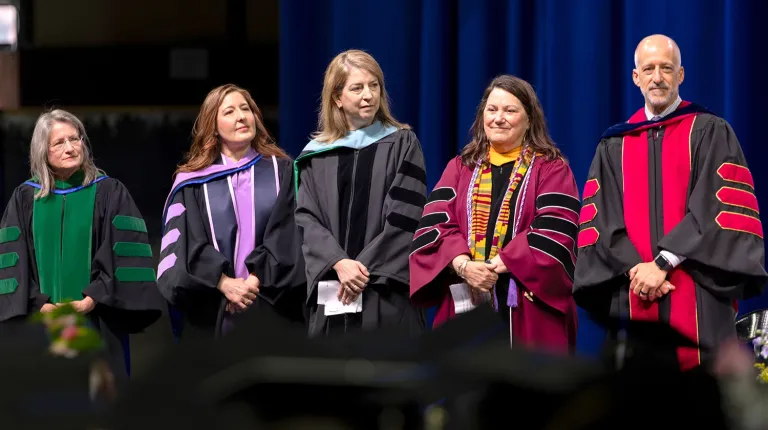 University of New England Deans stand before the graduates