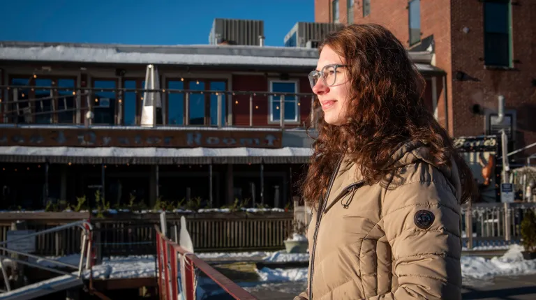 Samantha Ryea smiles while standing along the Portland, Maine waterfront