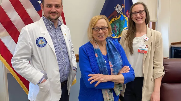 A medical student and Maine Medical Center representative pose with Maine Gov. Janet Mills