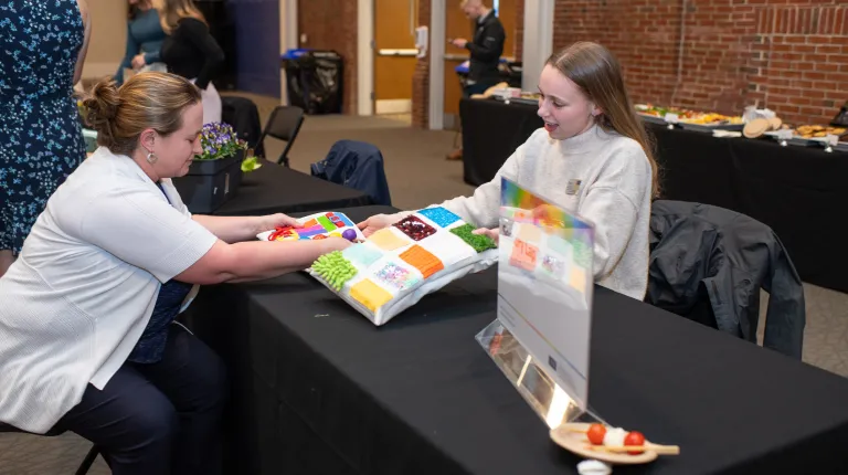 A woman tests a sensory board made by a student