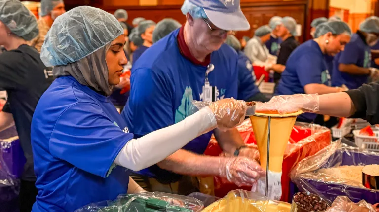 Since starting in 2023, UNE’s large-scale, meal-packaging effort had produced 300,000 meals for individuals and families throughout the state; Wednesday’s event brought that number to 350,000. The Masonic foundation joined the effort last fall to help the program reach all 16 counties in Maine for the first time.  UNE Service Learning Director Trisha Mason said in her opening remarks that the Meals for Maine partnership with the Masons typifies UNE’s experiential-learning approach to education by providing 