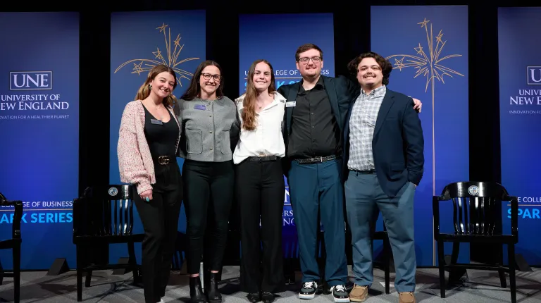 A group of students poses onstage