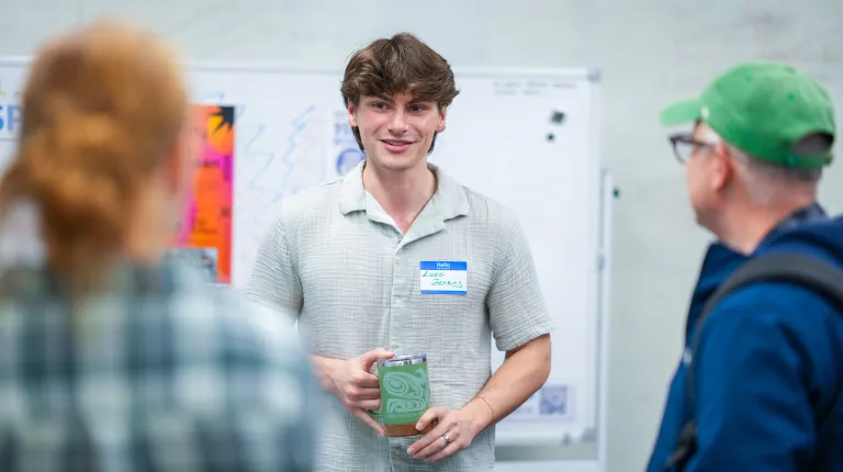 A UNE student smiles while presenting at the 2026 Innovation Showcase