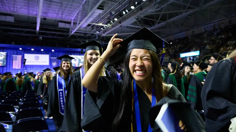 A student celebrates at UNE's 2026 Commencement