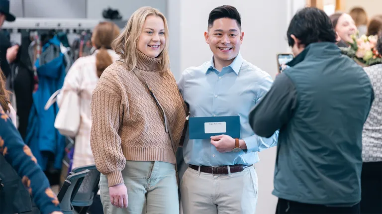 A U N E College of Osteopathic Medicine student poses for a photo with a family member while holding his Match Day envelope.