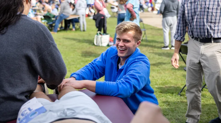 A student smiles while treating a runner