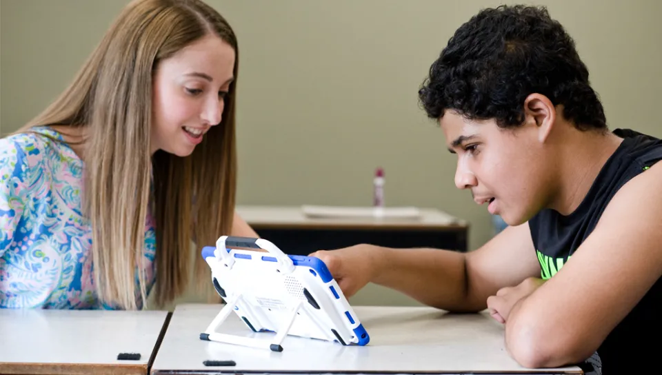 A U N E student works with a special education student