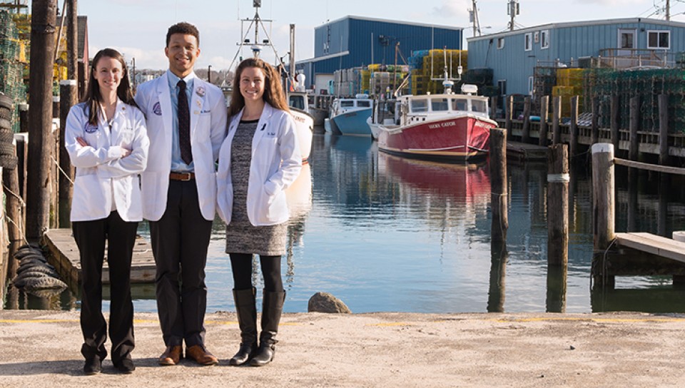 Three graduate students standing by the Widgery Wharf in Portland, Maine