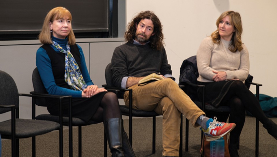Three individuals sitting at the front of the lecture hall during the climate teach-in
