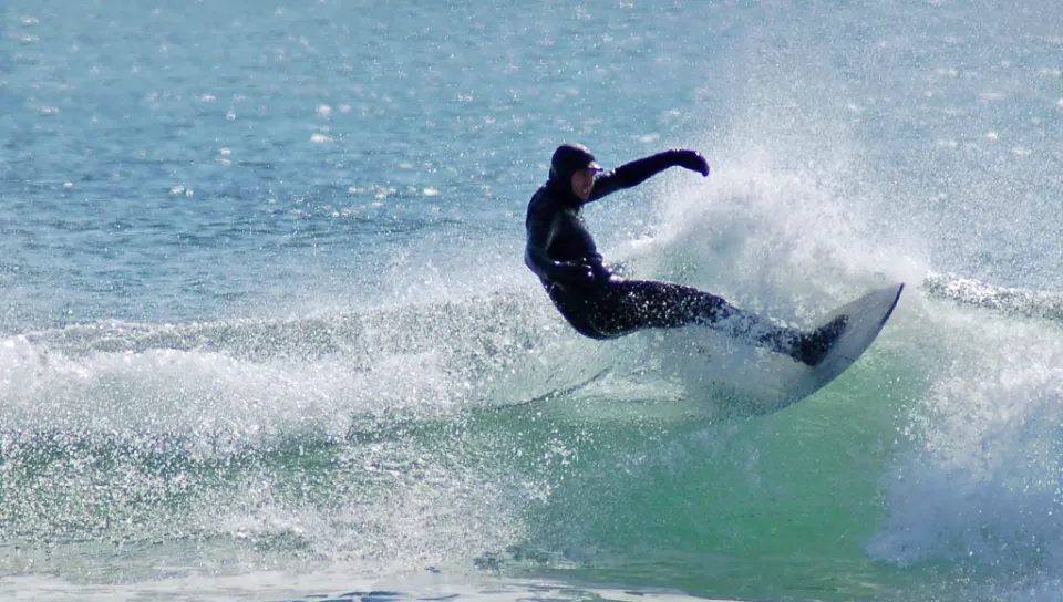 A student catching a wave while surfing