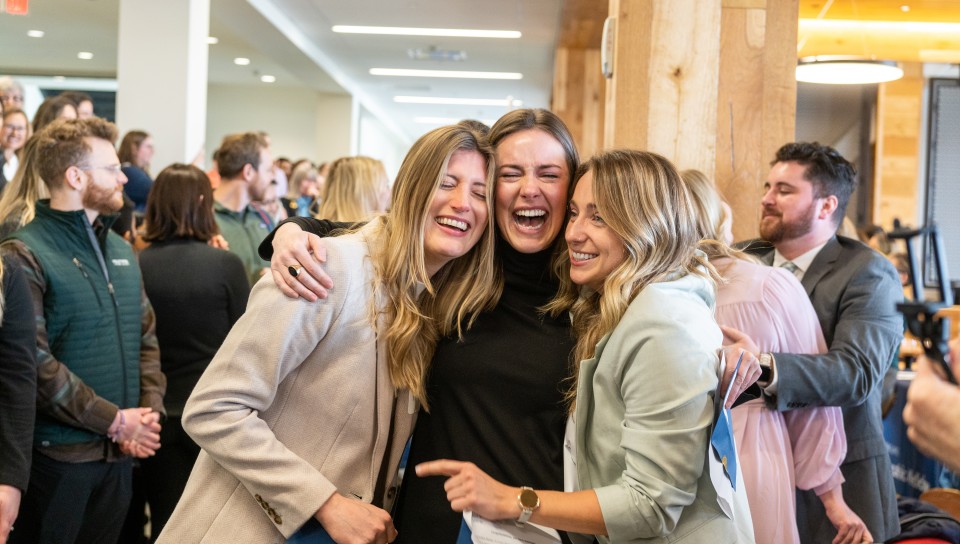 Three female students hug after learning their residency matches