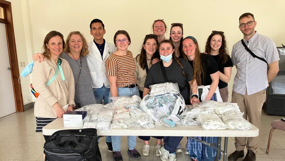 A group of students poses with medical equipment on a table