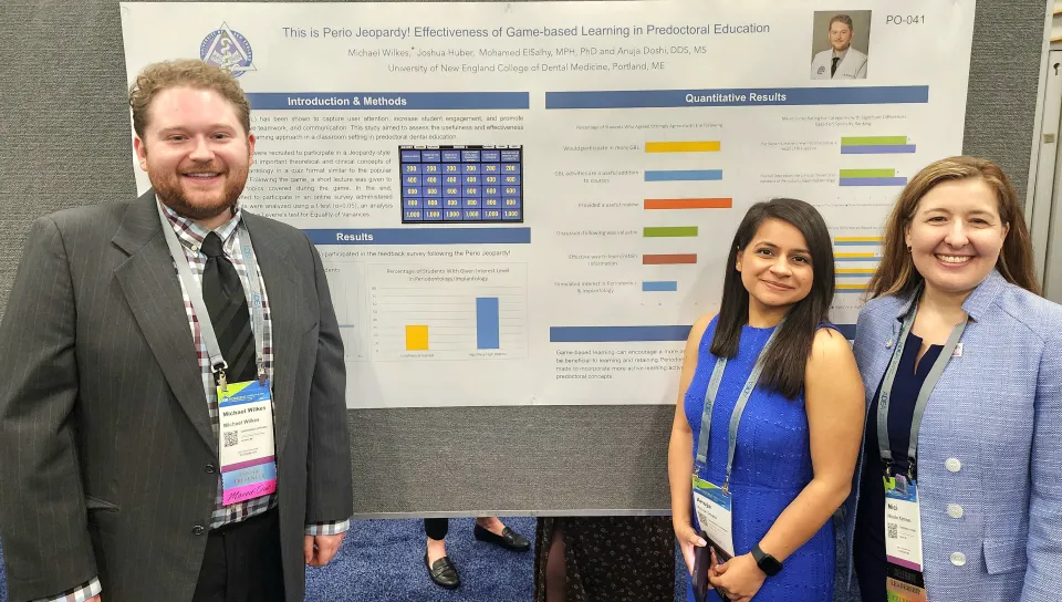 Two students pose in front of their research poster with CDM Dean Nici Kimmes