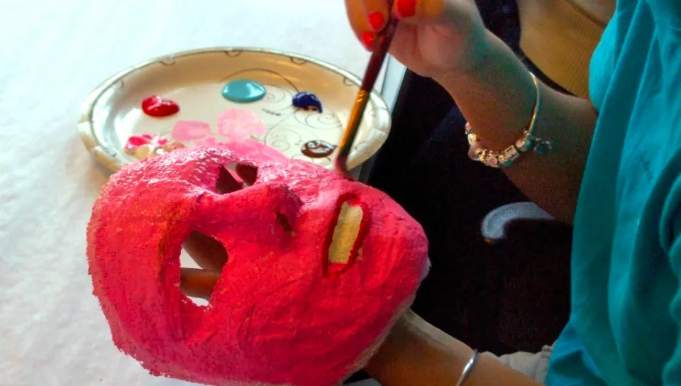 A student painting a mask