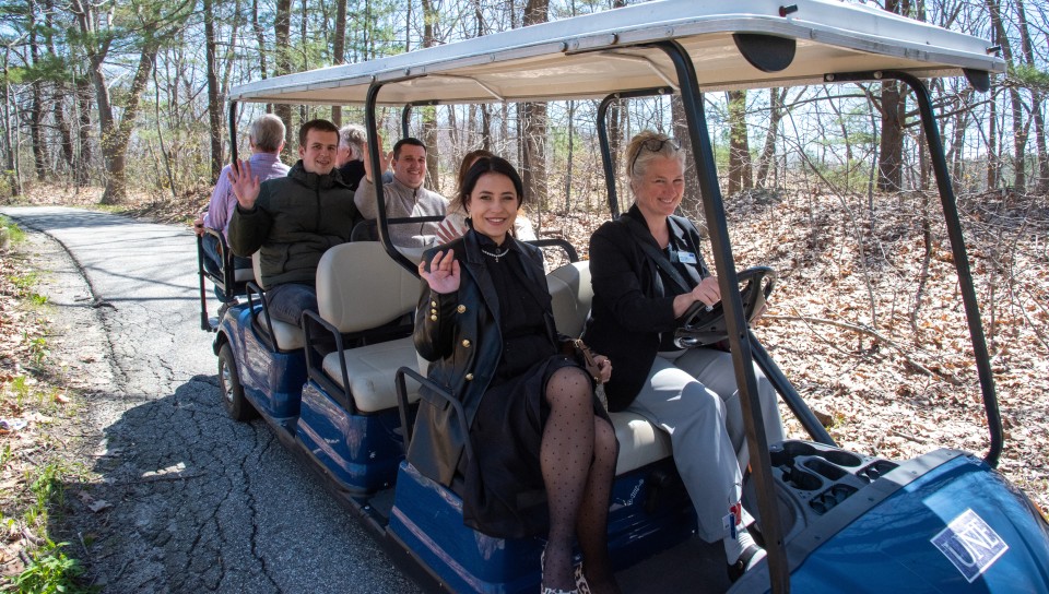 The Ukrainian delegates ride in a UNE golf cart driven by sustainability director Alethea Cariddi