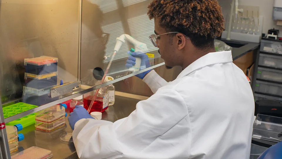 A student uses lab tools for research