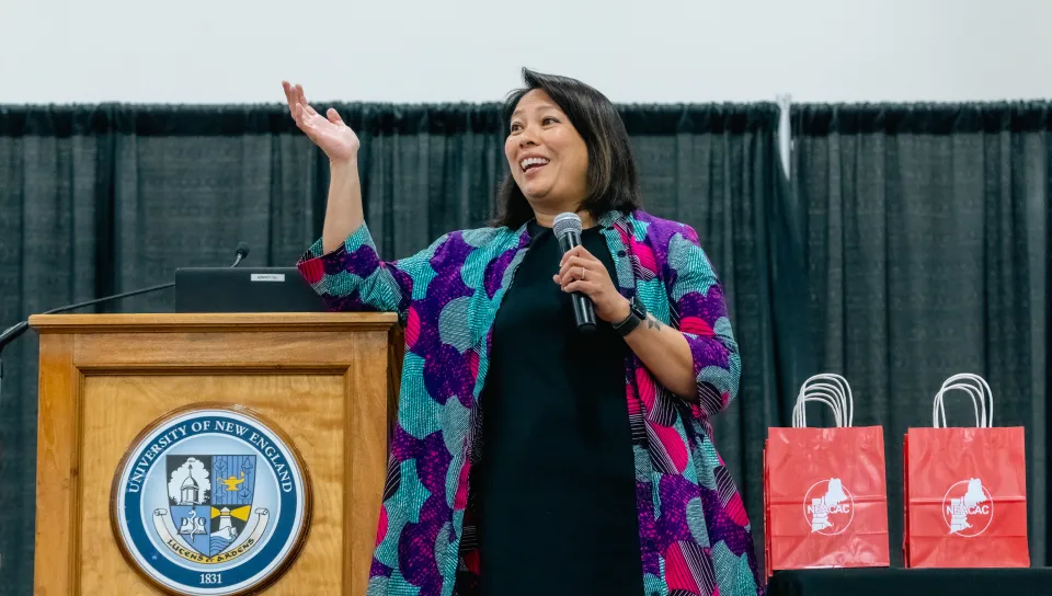 A woman speaks into a microphone on stage