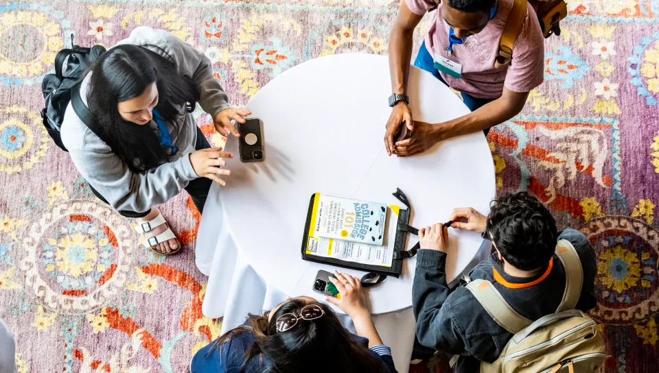 Attendees gather around a table