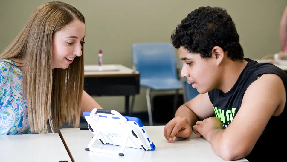 A U N E student specializing in special education helps a middle school student