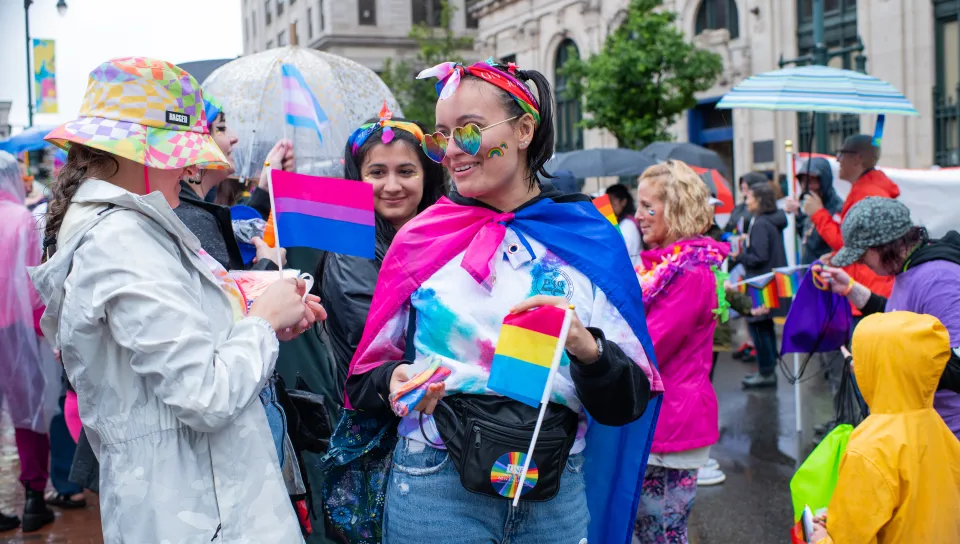 A UNE student holds a Pride flag amid many others from the UNE community