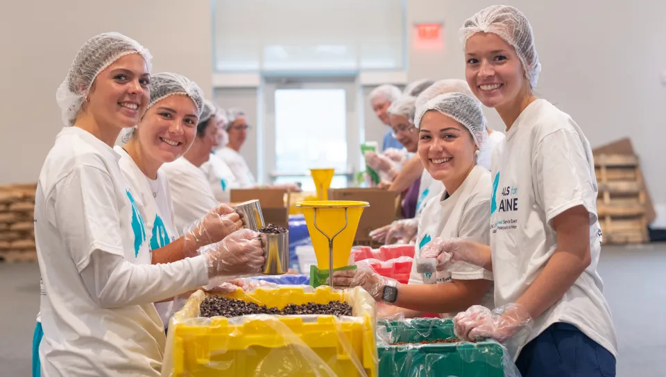 A group of students pack rice and beans for the Meals for Maine event
