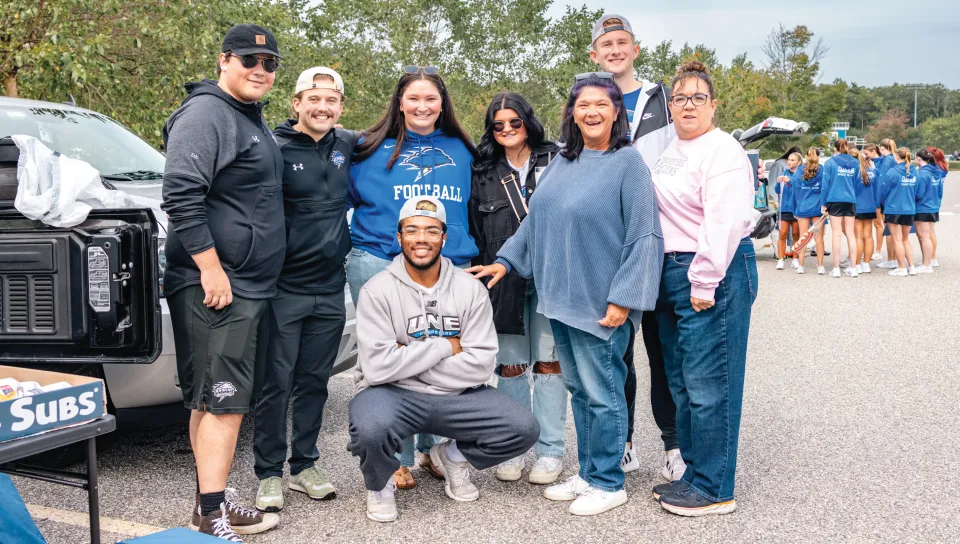 A family poses together at a U N E football tailgate