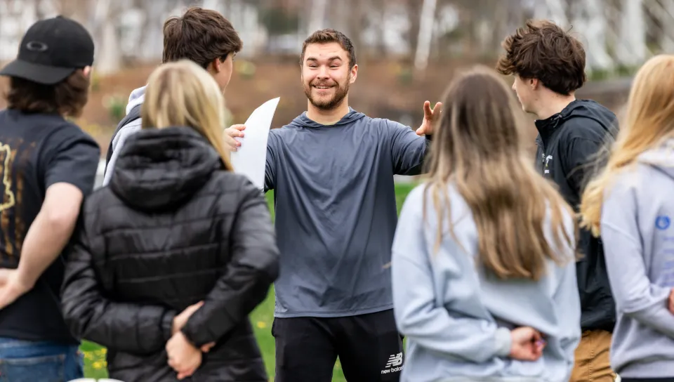 A UNE student gives game instructions to a group of high schoolers