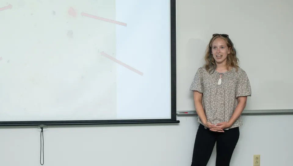 A UNE student presents her research on a slideshow