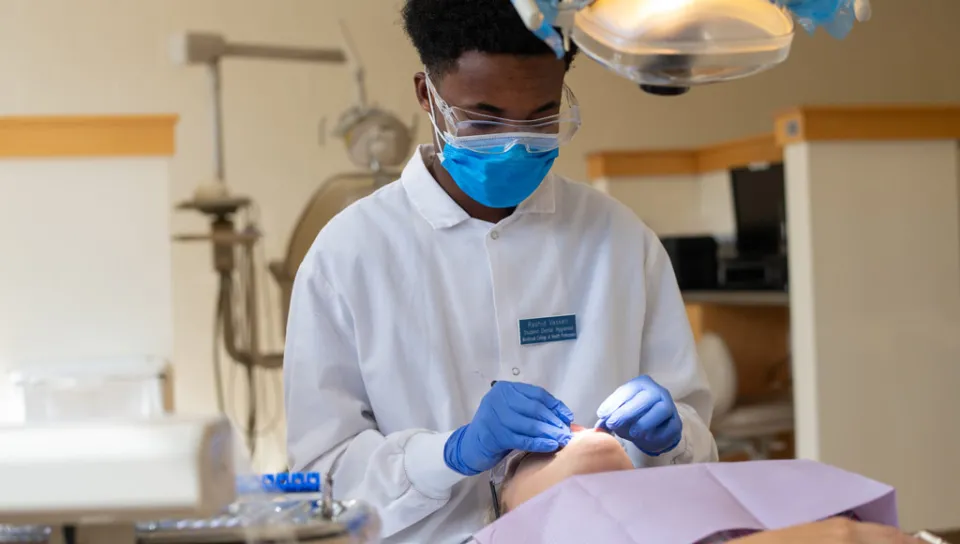 A dental hygiene student checks the facial and neck lymph nodes of a patient