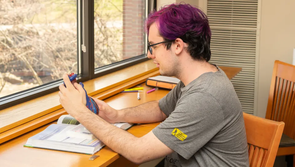 A student reviews the anatomical model of a heart