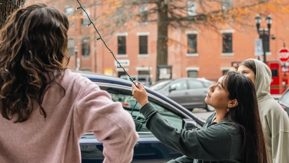 UNE students help to decorate Biddeford with lights.