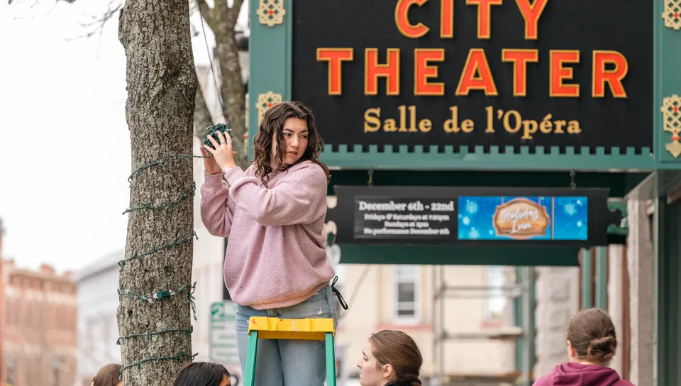 UNE students help to decorate Biddeford with lights.
