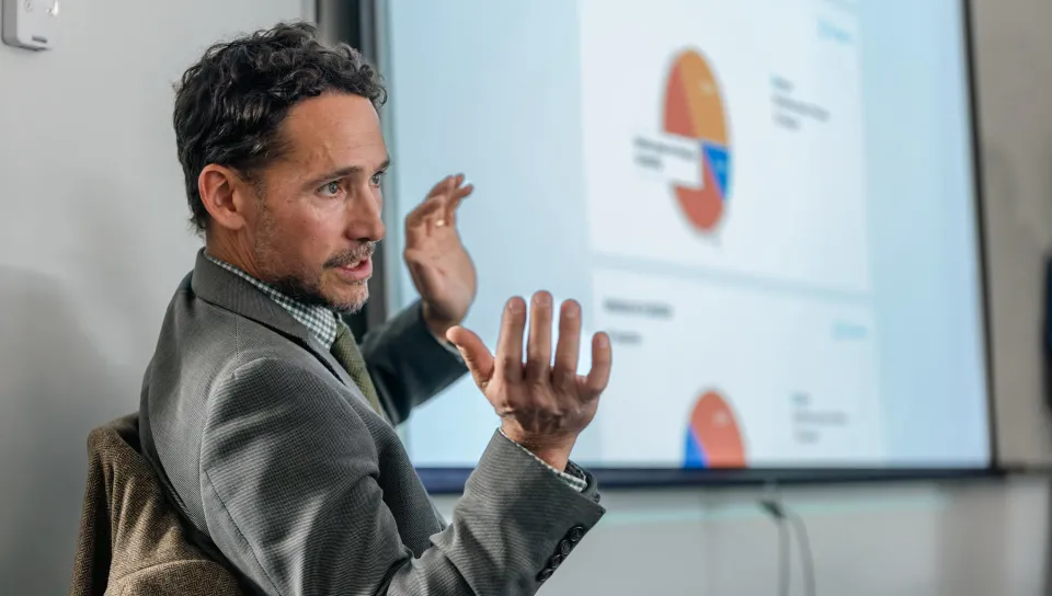 A UNE professor leads discussion in front of a presentation