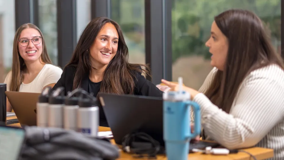 Members of the Women in Business Club talk at a conference table
