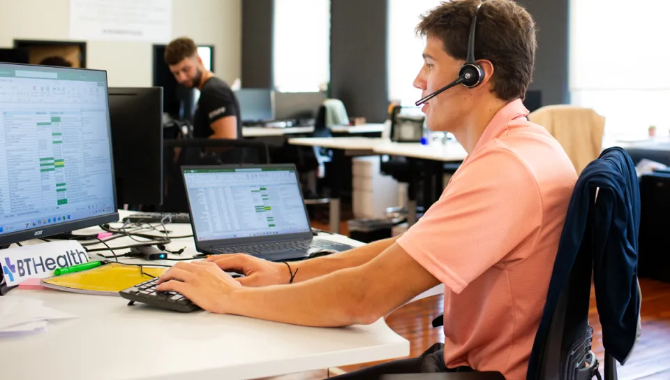 A Business Administration student sits in an office setting for his sales internship