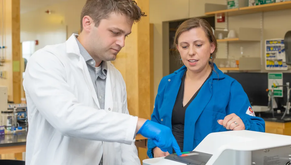 UNE student, Peter Swanson, and UNE faculty member, Eva Rose Balog using equipment in her lab