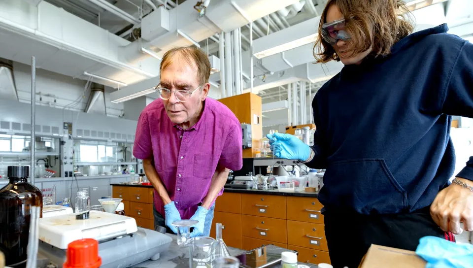 Stephen Fox and a UNE student examine a research sample set on lab equipment