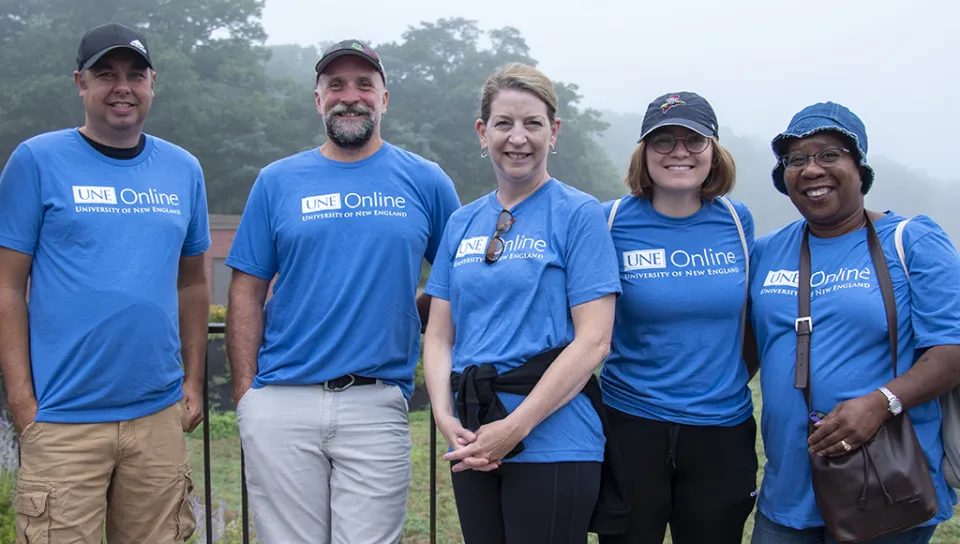 Employees from U N E Online pose with President Herbert