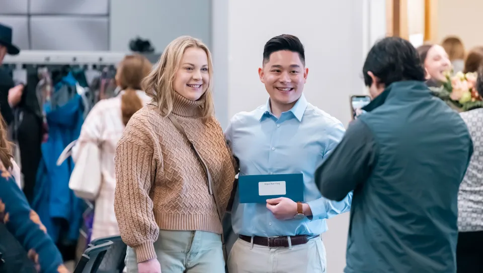 Two students pose for a photo holding a Match Day envelope