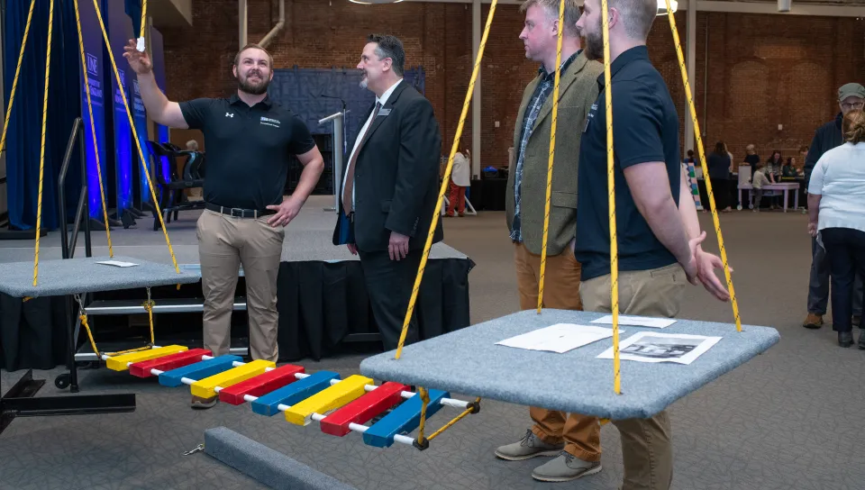 Students demonstrate their custom-made sensory swing set and playground bridge 