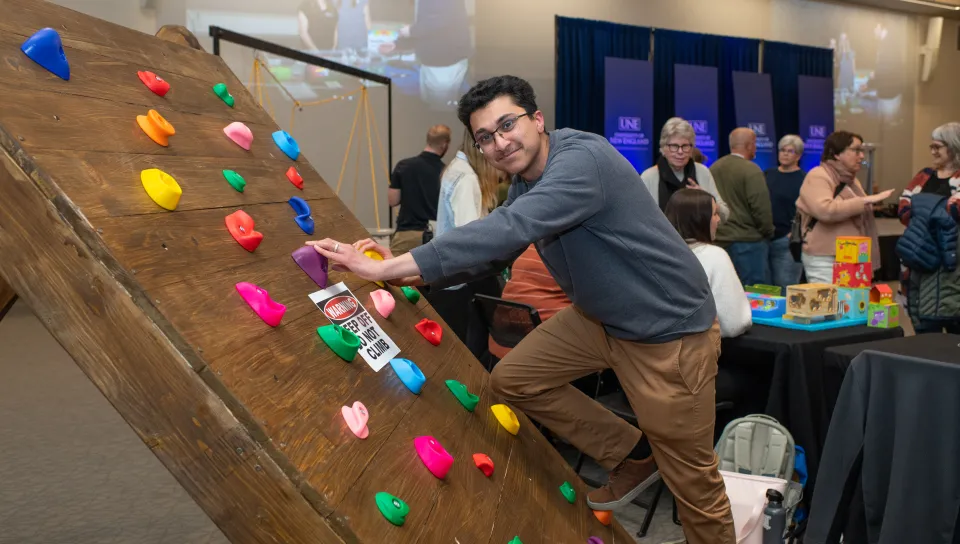 A student demonstrates their custom-built climbing wall