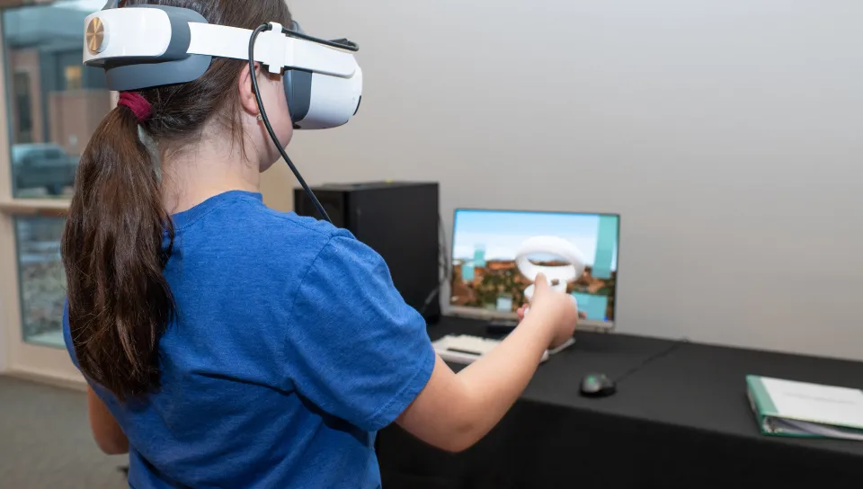 A child plays Minecraft using a virtual reality headset